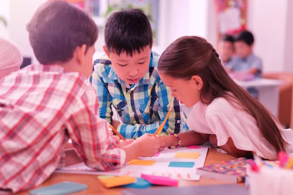 Enfants travaillant ensemble sur leur projet scolaire . — Photo