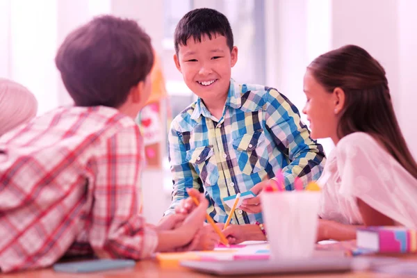 Lachende jongen tekenen met zijn vrienden in de klas. — Stockfoto