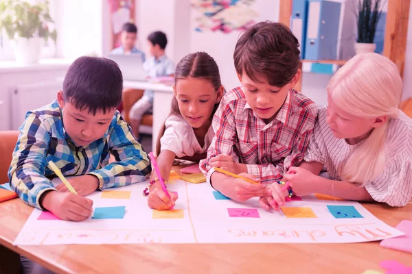 Compañeros de clase haciendo proyecto escolar sobre sus sueños . —  Fotos de Stock