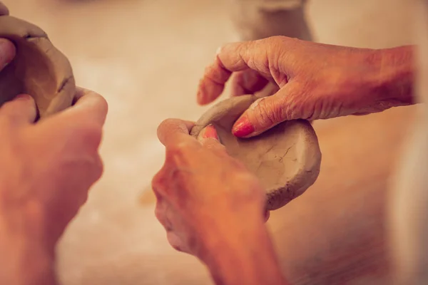 Mains d'une belle femme âgée faisant des pots — Photo