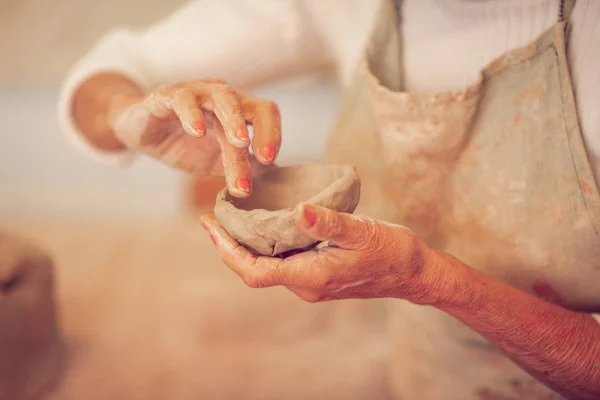 Close up of a clay bowl in female hands — Stock Photo, Image