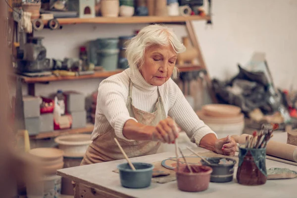 작업장에서 일하는 진지한 노인 여성 — 스톡 사진