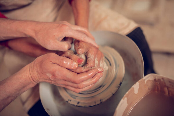 Top view of human hands in clay