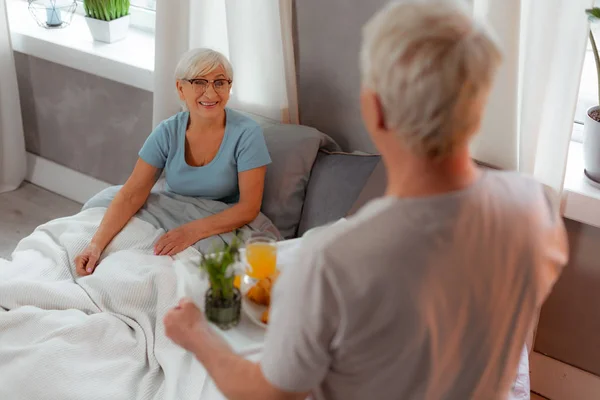 Strahlendes altes Weibchen, das im Bett liegt — Stockfoto