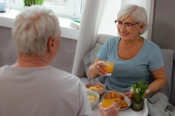 Zářící žena, která má s manželem džus a snídani s obilovinami — Stock fotografie