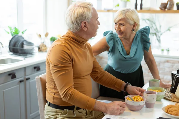 Happy contended beaming agradável atraente cônjuges idosos atraentes falando durante o café da manhã — Fotografia de Stock