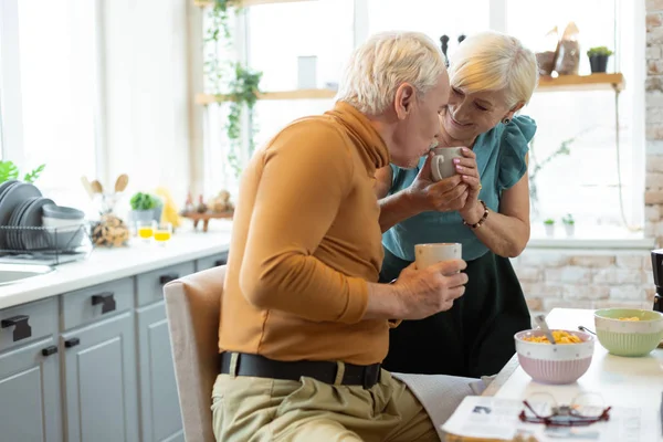 Liefdevolle zorgzame man zoenen de hand van zijn bejaarde vrouw — Stockfoto