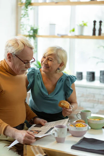 Бадьорості подружжя насолоджуються сніданком і розмовою на кухні — стокове фото