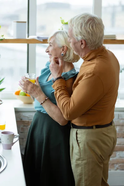 Полноразмерный снимок мужчины, обнимающего жену на кухне — стоковое фото