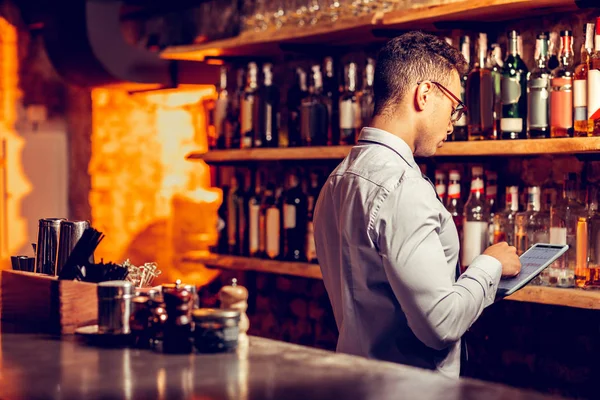 Homme d'affaires utilisant la tablette tout en commandant de l'alcool pour le bar — Photo