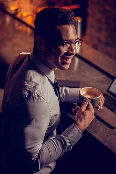 Handsome freelancer smiling having little coffee break — Stock Photo, Image