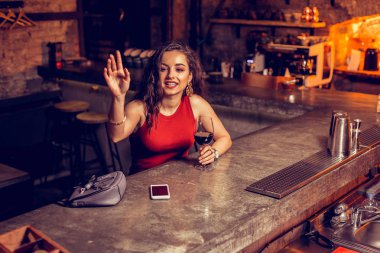 Barmen ararken şık kadın elini kaldırarak