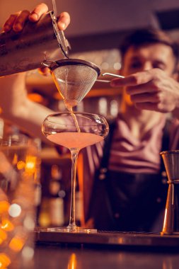 Koyu saçlı barmen eve kullanarak mango suyu dökme