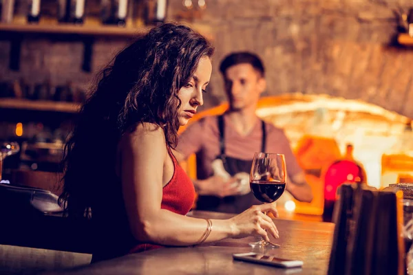 Jovencita de pelo largo sintiéndose mal sentada sola en el bar — Foto de Stock