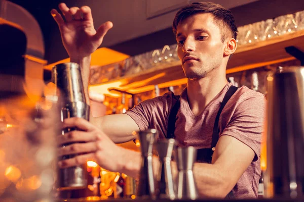 Gutaussehender Barmann, der sich involviert fühlt, während er Cocktails für Kunden herstellt — Stockfoto