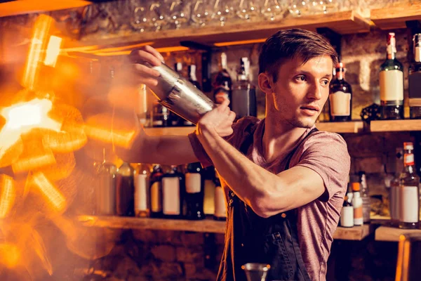 Young but experienced barman making cocktail for client — 스톡 사진