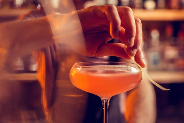 Barman drying drops of juice from glass with cocktail — Stock Photo, Image