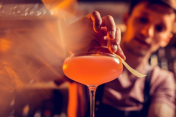 Barman aperfeiçoa coquetel para seu cliente enquanto trabalha à noite — Fotografia de Stock