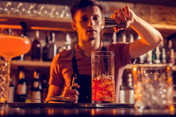 Homem trabalhando no bar derramando álcool em vidro — Fotografia de Stock