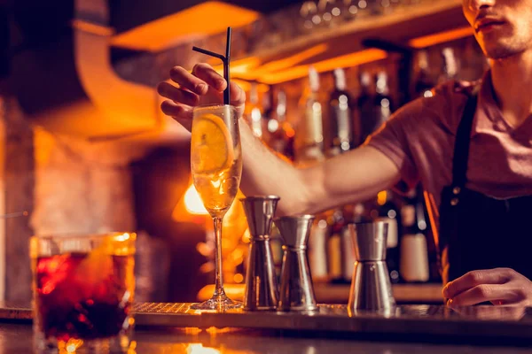 Cantinero poniendo paja en vaso de cóctel con limón — Foto de Stock