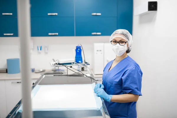 Tierarzt mit blauer Uniform und Maske bereitet sich auf Operation vor — Stockfoto