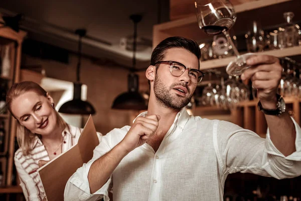 Attentive bearded male person looking at glass — Stock Photo, Image
