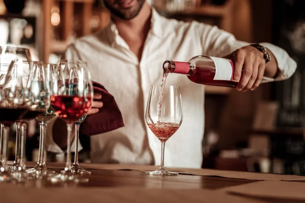 Jeune barman professionnel versant du champagne rose — Photo