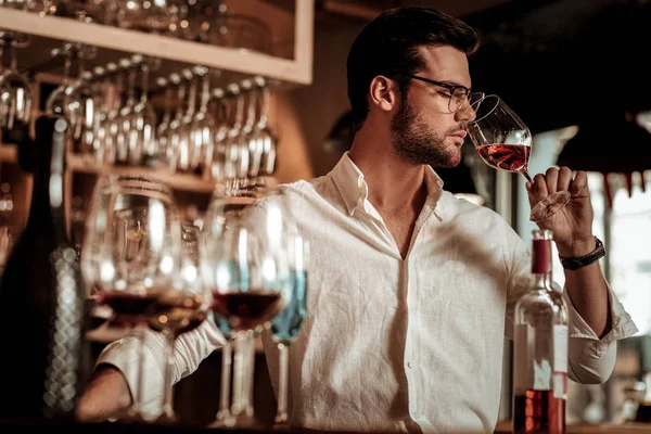 Jeune homme barbu sentant arôme de boisson rose — Photo