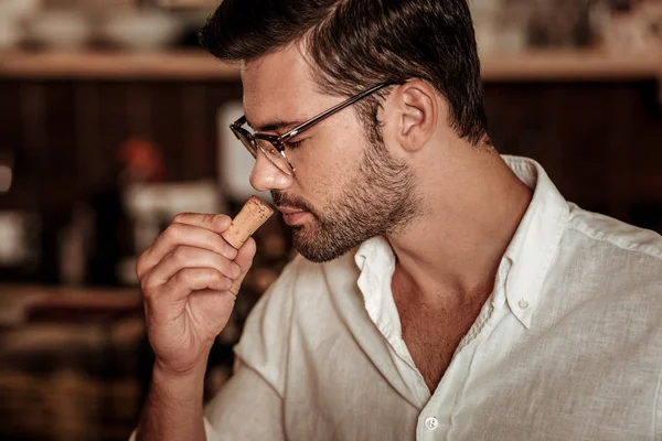 Крупный план брюнетки мужчина, что запах пробки — стоковое фото