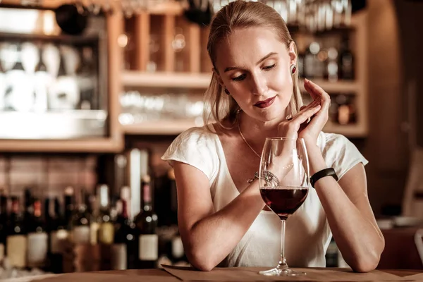 Mujer joven relajada mirando bocal de vino — Foto de Stock