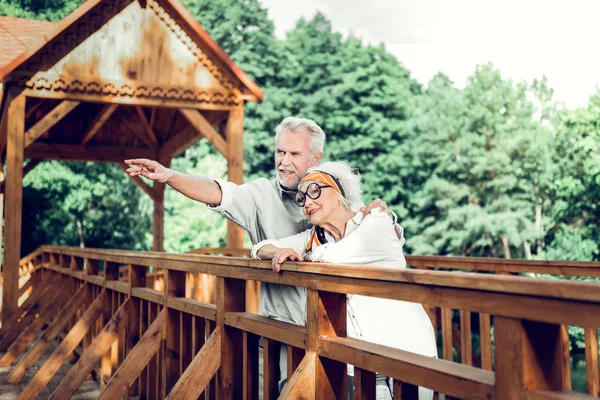 Veselý pár stojící na dřevěném krásném hnědém mostě — Stock fotografie