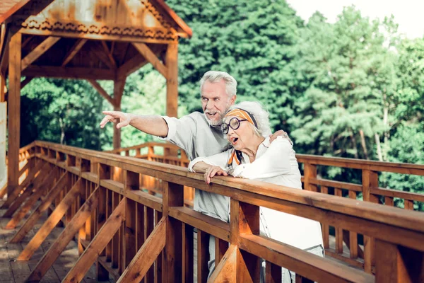 Esposa atraente e marido em pé na ponte de madeira — Fotografia de Stock