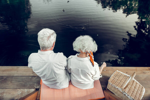 Back shot of spouses spending time on the lake