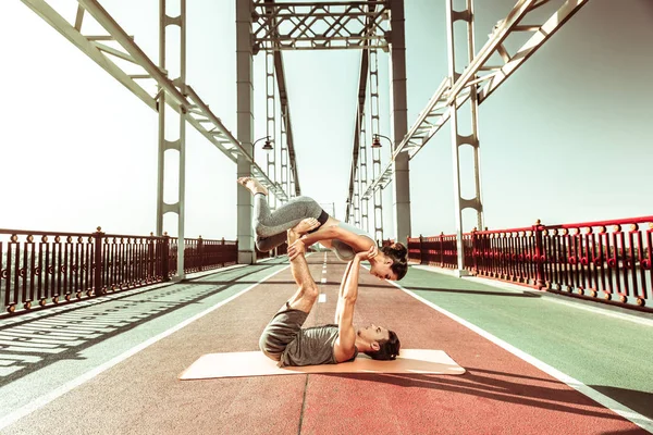 Girl engaged in acrobatic yoga with her partner — Stock Photo, Image