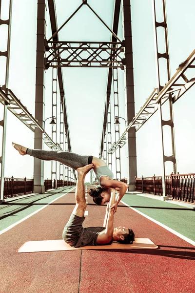 Люди делают акробатические упражнения на пешеходном мосту — стоковое фото