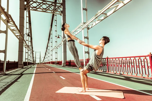 Jovem casal caucasiano praticando ioga acrobática juntos ao ar livre — Fotografia de Stock