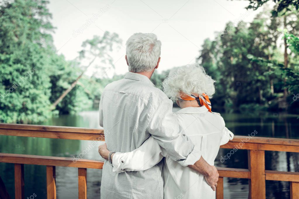 Back photo of couple wearing white clothing hugging each other