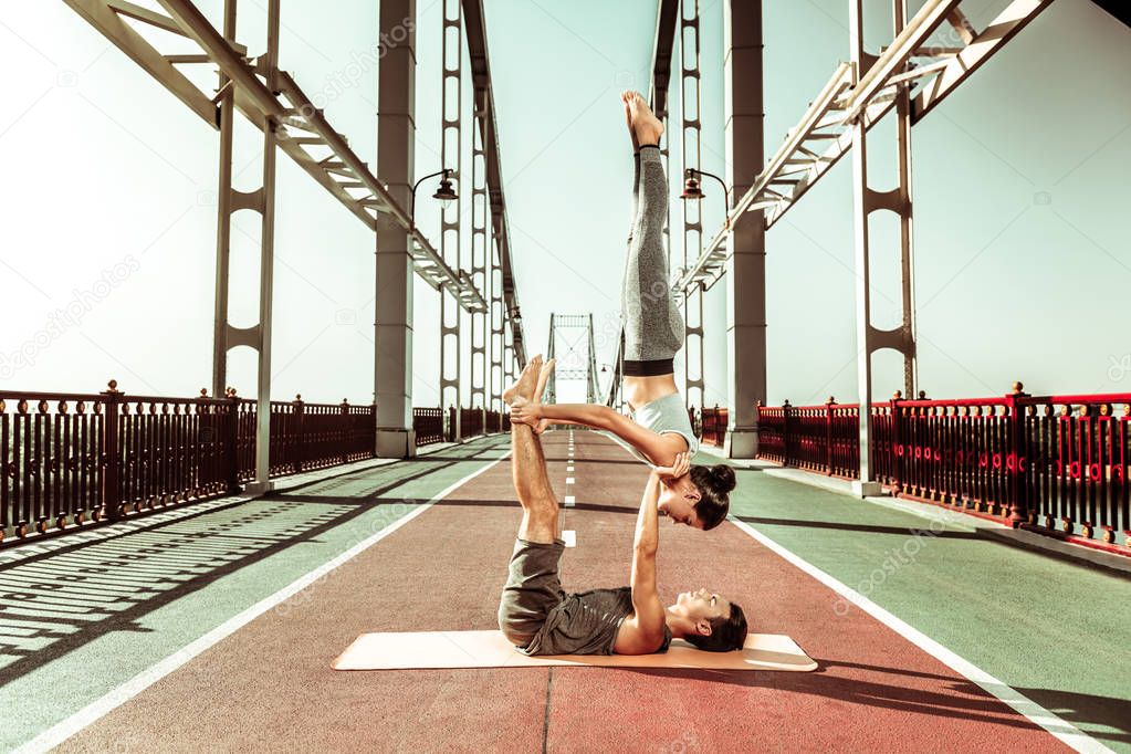 Sporty fit couple doing a candlestick yoga pose