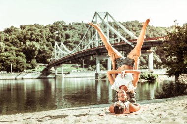 Fit genç kız Kafkas bir akroyoga poz yapıyor