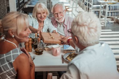 Her iki elinde hediye kutusu tutan neşeli kadın kişi