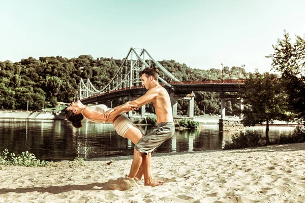 Menina alegre e seu parceiro praticando acroyoga ao ar livre — Fotografia de Stock