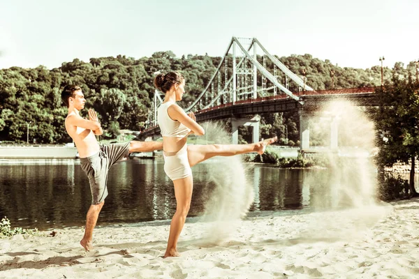 Athletic young couple practicing on the city beach