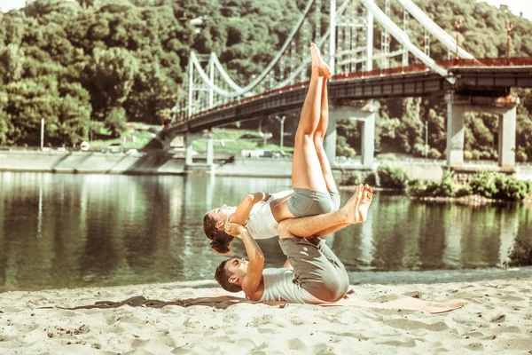 Jovem bronzeado exercitando com seu parceiro de ioga — Fotografia de Stock