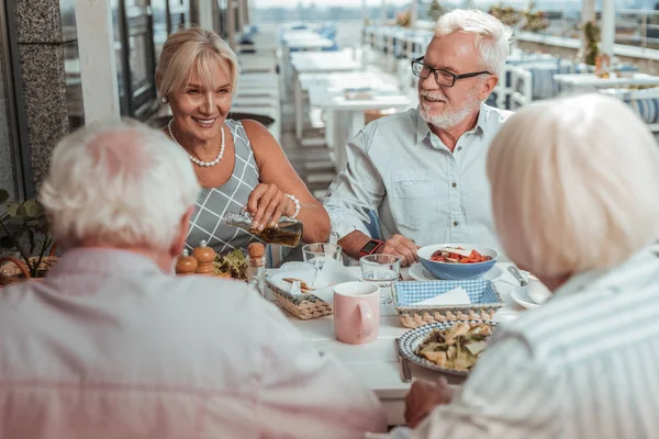 긍정적 인 기뻐하는 노인 부부는 밖에서 저녁 식사를 — 스톡 사진