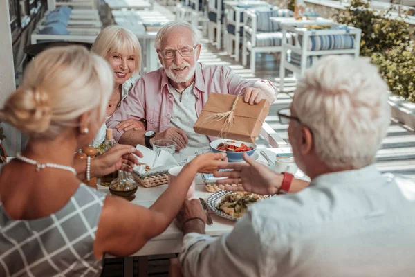 Glad äldre manliga person som presenterar presentförpackning — Stockfoto