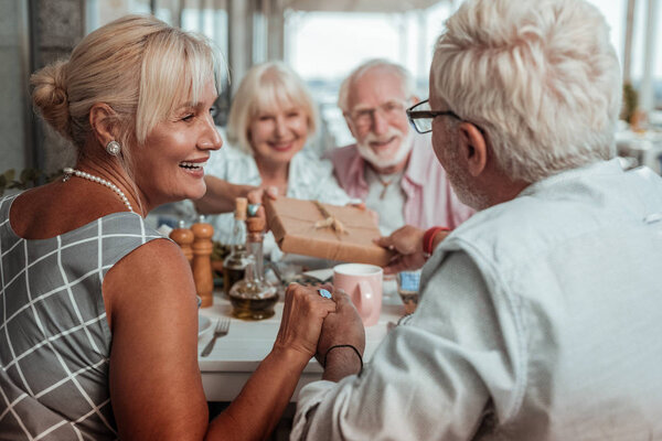 Очаровательная пожилая женщина смотрит на своего мужа
