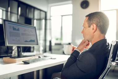 Yakışıklı işadamı bilgisayarda mali makale okuma