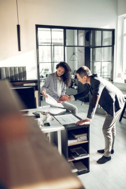 Olgun işadamı sekreteri ile konuşurken koyu ceket giyiyor
