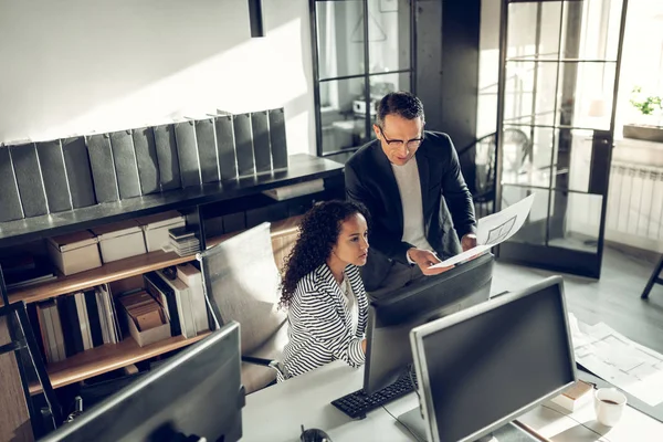 Mujer joven hablando con su jefe en una oficina espaciosa — Foto de Stock