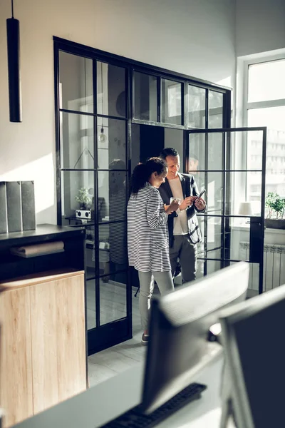 Kadın ve patronu ayaktalar ve konuşuyorlar.